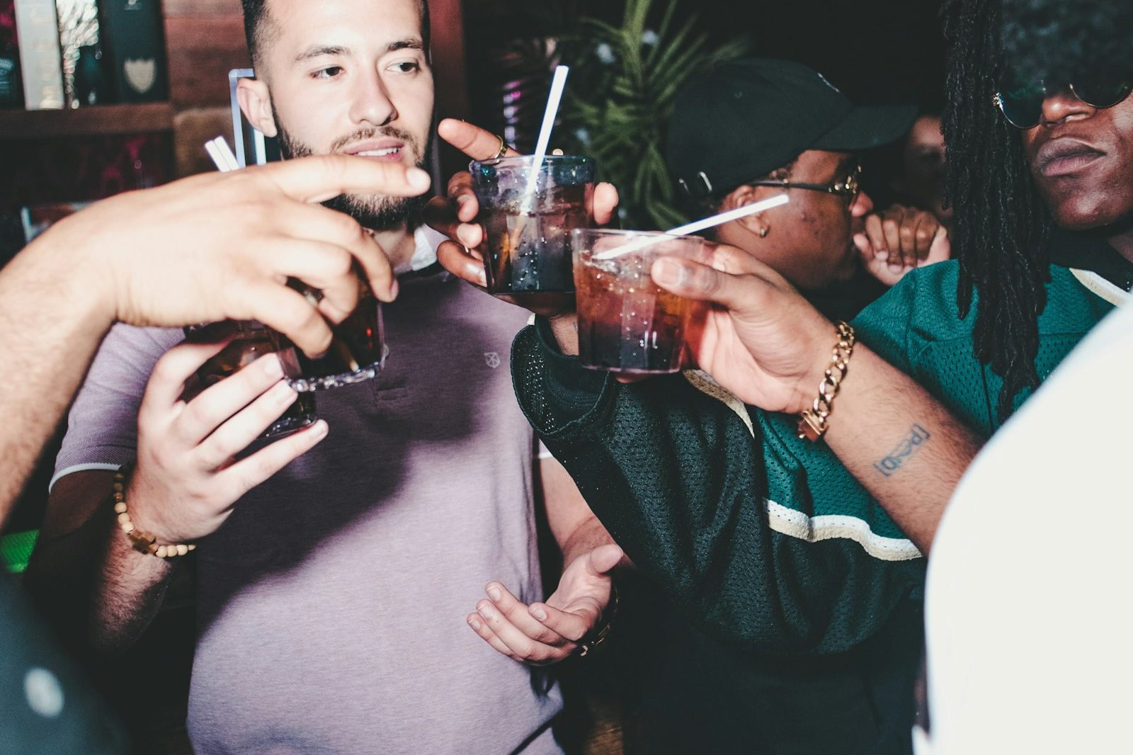 Guests laughing together with drinks in hand at an evening party in a dark venue